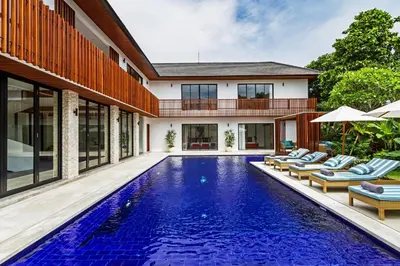 a swimming pool in the backyard of a house with lounge chairs at THE BOTANICAL 6 BED LUXURY 900 meter from beach in Seminyak