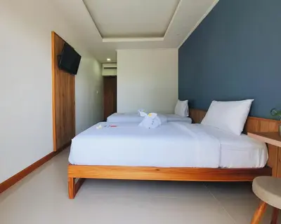a bedroom with a bed with a teddy bear on it at RakaAyu Kuta in Kuta