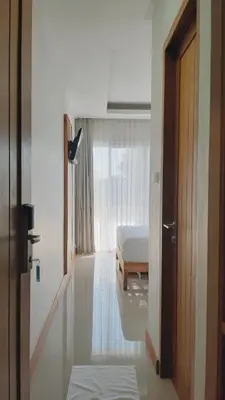 a room with a bed and a door to a bedroom at RakaAyu Kuta in Kuta