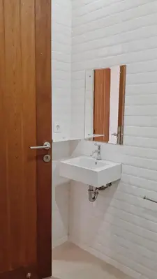 a bathroom with a white sink and a mirror at RakaAyu Kuta in Kuta
