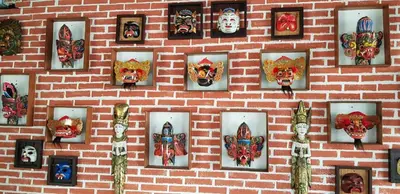 a wall with pictures of clowns on a brick wall at Puri Naga Beachfront Cottages in Legian