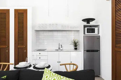 a kitchen with a couch and a table and a refrigerator at Villa Alfie in Seminyak