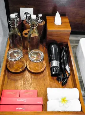 a table with glass bottles and a phone on it at Sampatti Villas in Seminyak