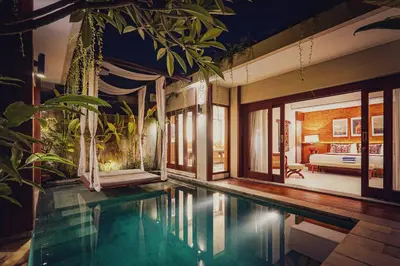 a house with a swimming pool and a bedroom at Sampatti Villas in Seminyak