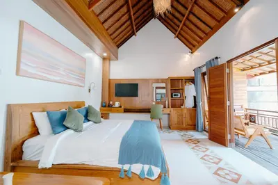 a bedroom with a bed and a desk and a television at Moson Villa Legian in Legian