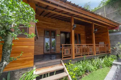 a wooden house with a bench in front of it at Moson Villa Legian in Legian