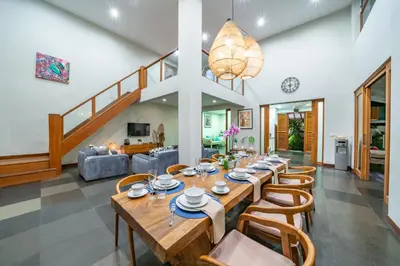 a dining room with a long table and chairs at Villa Litera Canggu Bali in Canggu