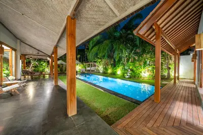 an indoor pool in a house with a wooden deck at Villa Litera Canggu Bali in Canggu
