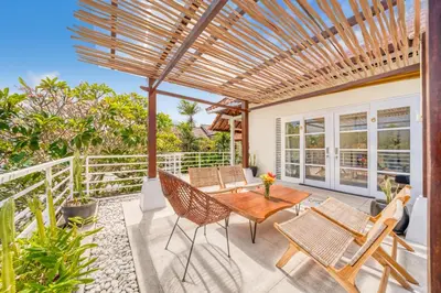 a patio with a wooden pergola and a table and chairs at Villa Milano - Private 6 BDR Villa in Seminyak, prime Location, Pool & Garden in Canggu
