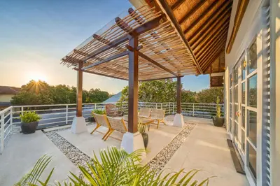 an outdoor patio with a wooden pergola at Villa Milano - Private 6 BDR Villa in Seminyak, prime Location, Pool & Garden in Canggu