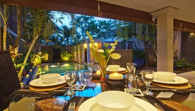 a table with plates and glasses on top of it at Harmony Villa Dua in Seminyak
