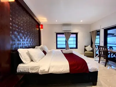 a bedroom with a large bed with a brick wall at Harmony Villa Dua in Seminyak