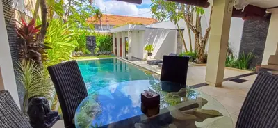 a patio with a table and a swimming pool at Harmony Villa Dua in Seminyak