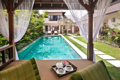 a villa with a swimming pool and a house at Villa Songket in Kerobokan