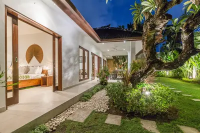 a bedroom in a villa with a tree at Bunga 2 in Seminyak