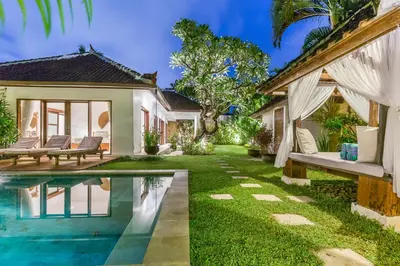 a backyard with a pool and a house at Bunga 2 in Seminyak