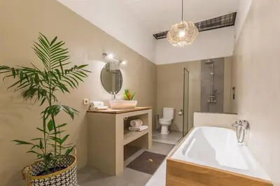 a bathroom with a tub and a plant in it at Pulesari 3 bedrooms in Seminyak