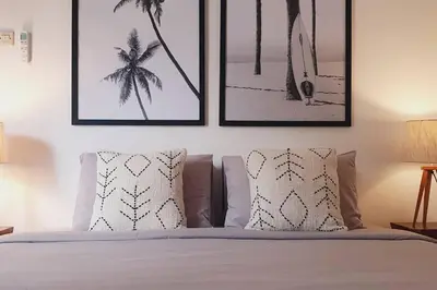 a bedroom with a bed with four pictures on the wall at Pulesari 3 bedrooms in Seminyak