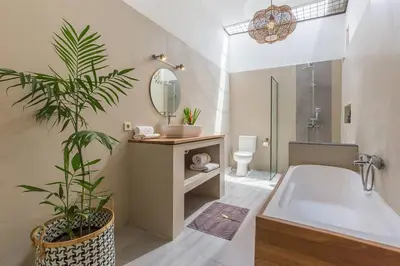 a bathroom with a tub and a sink and a mirror at Pulesari 3 bedrooms in Seminyak