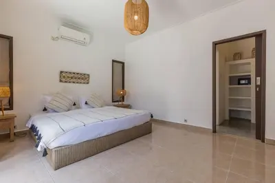 a bedroom with a large bed and a mirror at Pulesari 3 bedrooms in Seminyak