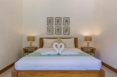a bedroom with two swans sitting on a bed at Pulesari 2 bedrooms in Seminyak
