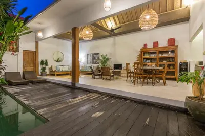a living room and dining room with a wooden floor at Pulesari 2 bedrooms in Seminyak