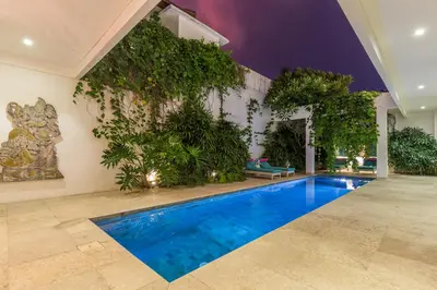 a swimming pool in a house with plants at Villa Lansel in Seminyak