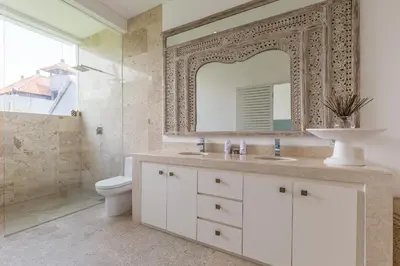a bathroom with a sink and a toilet and a mirror at Villa Lansel in Seminyak