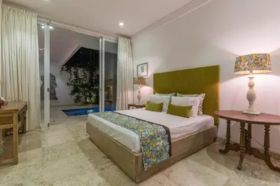 a bedroom with a bed and a desk and a lamp at Villa Lansel in Seminyak