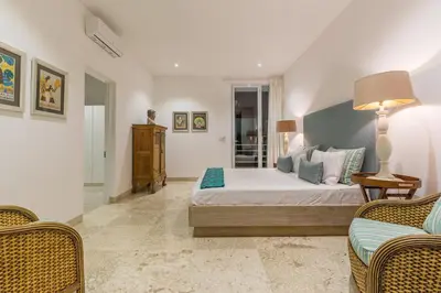 a bedroom with a bed and two chairs at Villa Lansel in Seminyak