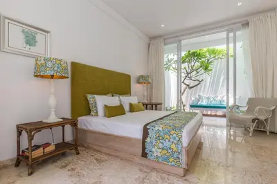 a bedroom with a bed and a large window at Villa Lansel in Seminyak