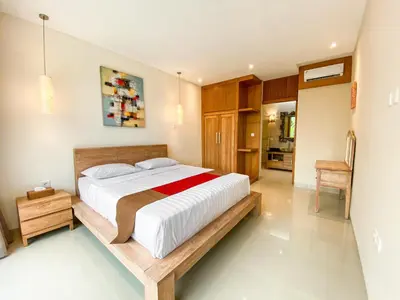 a bedroom with a large bed in a room at Svarna Suites Seminyak in Seminyak