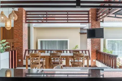 a dining room with a table and chairs at Svarna Suites Seminyak in Seminyak