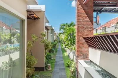 an alley between two buildings with plants at Svarna Suites Seminyak in Seminyak