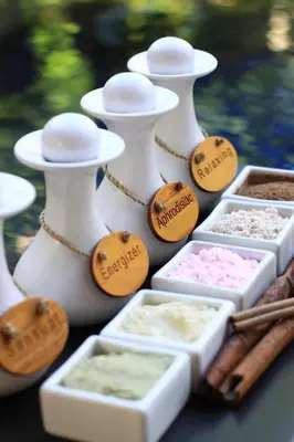 a table topped with white containers filled with different types of spices at The Haere Seminyak - By Astadala in Seminyak