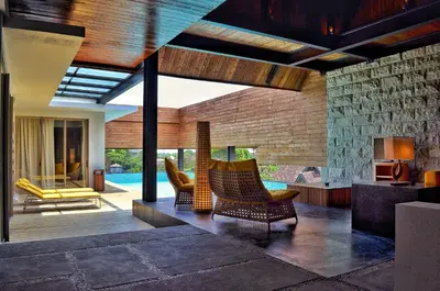 a living room with chairs and a swimming pool at TS SUITES Seminyak Bali in Legian