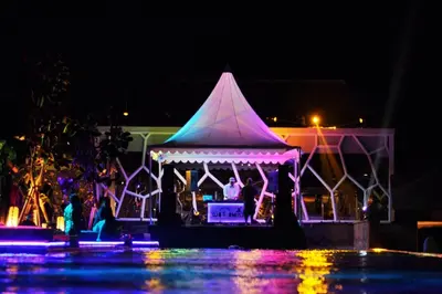 a gazebo with people in it at night at TS SUITES Seminyak Bali in Legian