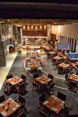 a dining room with wooden tables and chairs at TS SUITES Seminyak Bali in Legian