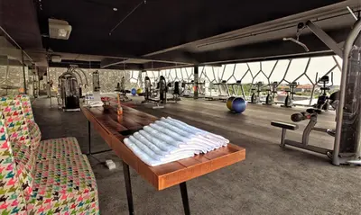a gym with a table with towels on it at TS SUITES Seminyak Bali in Legian