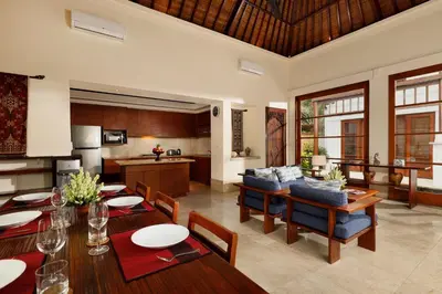 a kitchen and living room with a table and chairs at Jimbaran Beach Villas by Nakula in Jimbaran