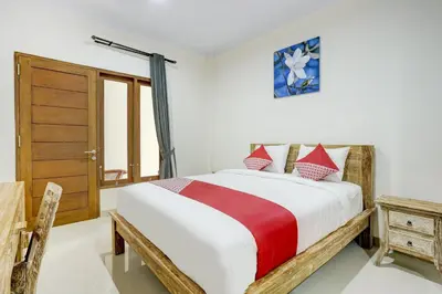 a bedroom with a bed and a wooden door at Hotel O March 67 Stay in Balian