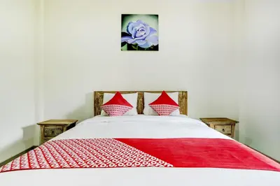 a bed with a red and white blanket on it at Hotel O March 67 Stay in Balian