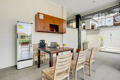 a kitchen with a table and chairs and a refrigerator at Hotel O March 67 Stay in Balian