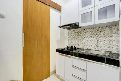 a kitchen with white cabinets and a sink at Hotel O March 67 Stay in Balian