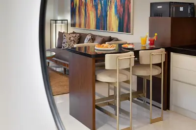 a kitchen and living room with a table and chairs at Beachwalk Residence in Kuta