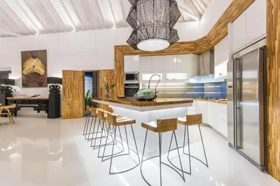 a kitchen with a bar with stools at Villa Lora in Seminyak