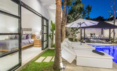a villa with a swimming pool and a bedroom at Villa Lora in Seminyak