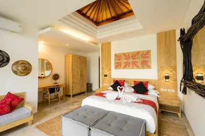 a bedroom with a large bed and a desk at Cascata Villa Canggu in Canggu