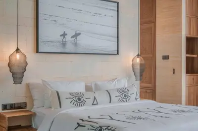 a bedroom with a bed and a picture on the wall at Villa Boya - 6BR luxury oasis in Central Berawa in Canggu