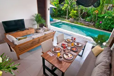 a living room with a table with food and a pool at 2BR Villa Violetta - Minggu Villas - Special Stay Bonus in Kerobokan
